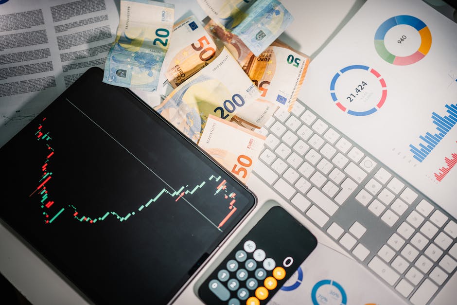 Overhead view of financial tools with Euro banknotes on a desk showing market trends and graphs.